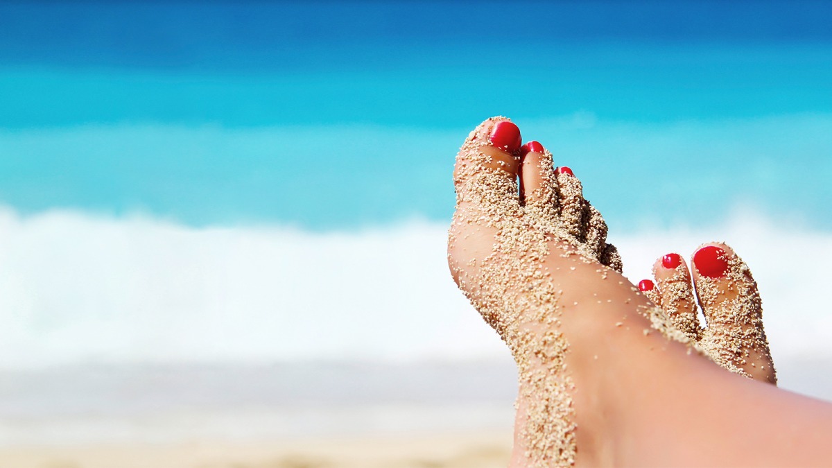 Sonne, Sand und Salzwasser: Im Urlaub warten einige Herausforderungen auf die Fußhaut und die lackierten Fußnägel. Foto: Drpixel/Shutterstock.com